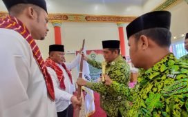 Ketua Pengurus Wilayah Dewan Masjid Indonesia (DMI) Sumatera Utara Irhamuddin Siregar menyerahkan bendera pataka DMI kepada Ketua PD DMI Kabupaten Karo Meliala Purba. (karodaily/adhif)