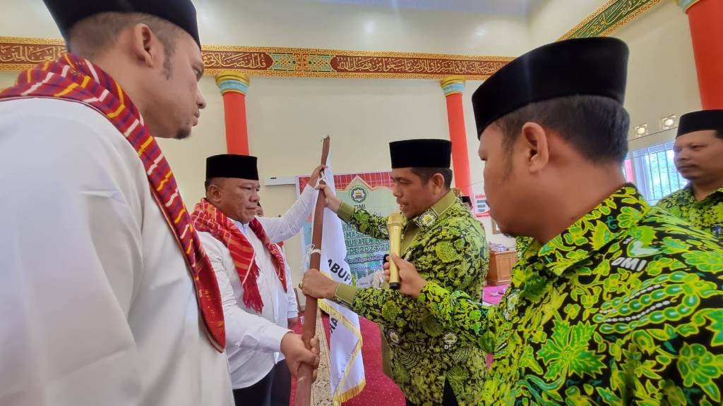 Ketua Pengurus Wilayah Dewan Masjid Indonesia (DMI) Sumatera Utara Irhamuddin Siregar menyerahkan bendera pataka DMI kepada Ketua PD DMI Kabupaten Karo Meliala Purba. (karodaily/adhif)