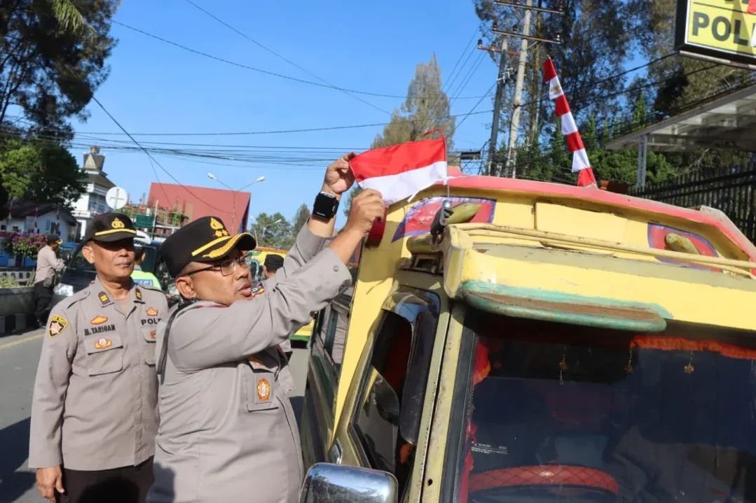 Kapolres Tanah Karo Bagikan Bendera Merah Putih kepada Pengendara